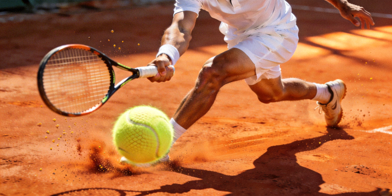 网球运动员在红土场地上奋力挥拍击球